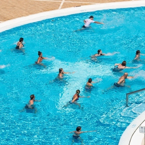 a group of people are doing exercises in a large swimming pool