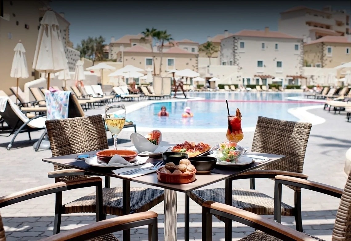 una mesa con copas de vino y un espejo con la palabra ajaj en la pared