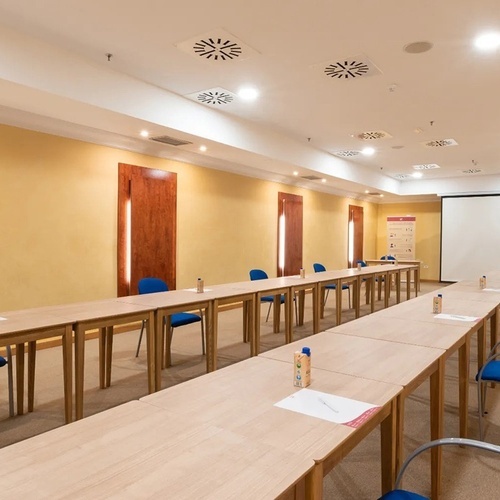 a conference room with long tables and blue chairs