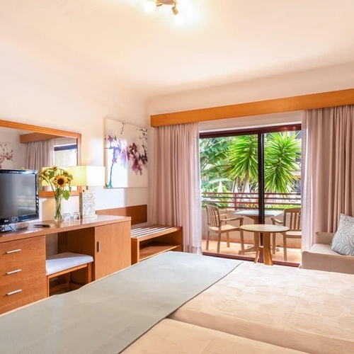 a hotel room with a couch and a flat screen tv