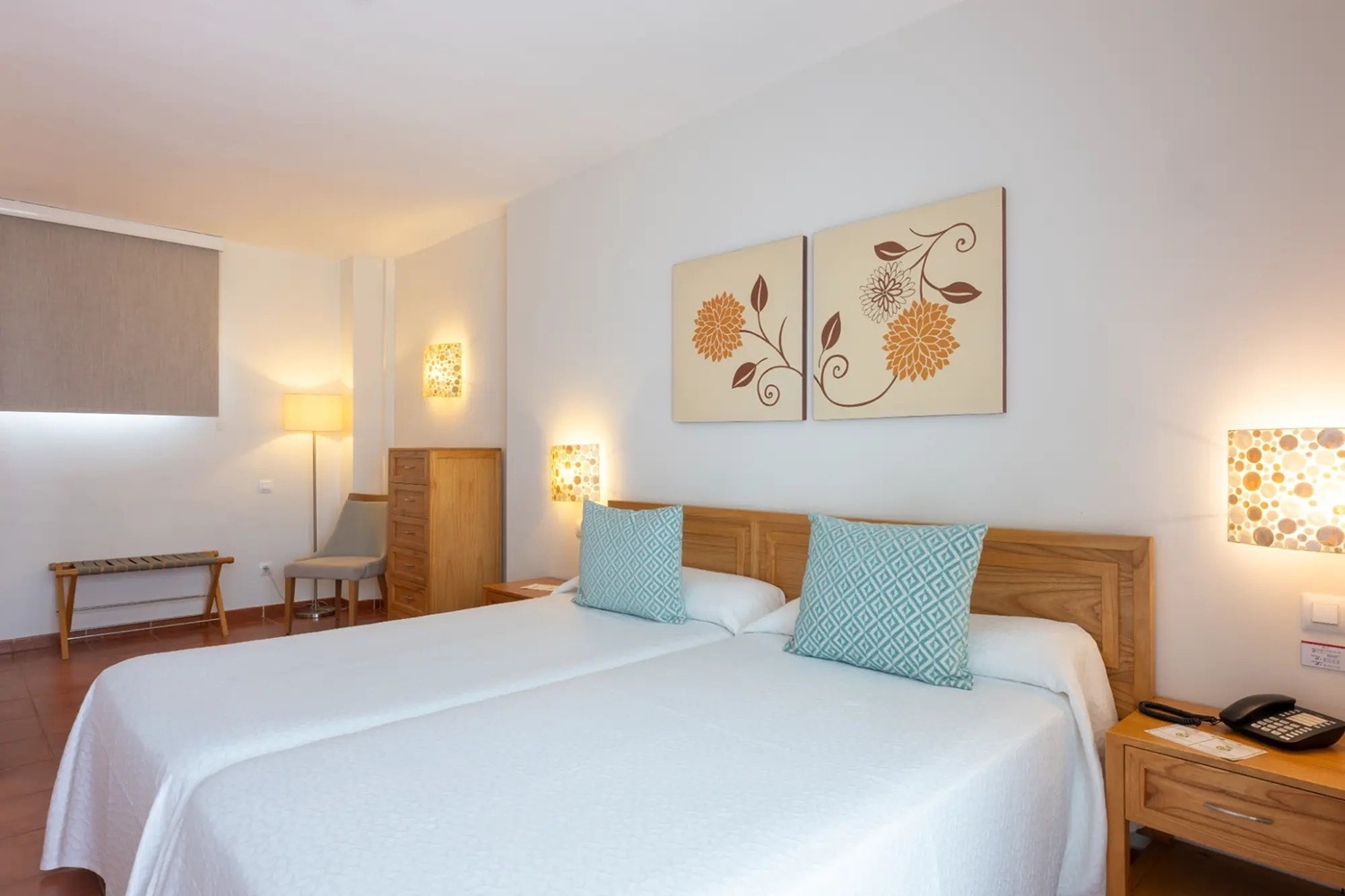 una habitación con dos camas y dos cuadros en la pared