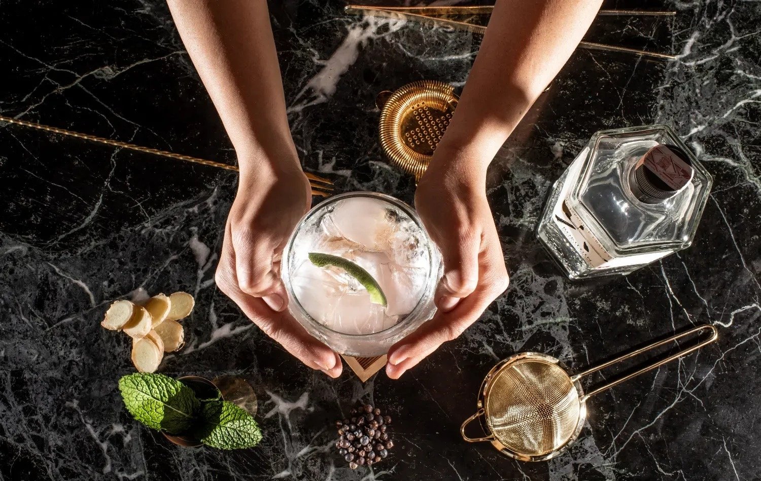 a person is holding a glass with a lime in it