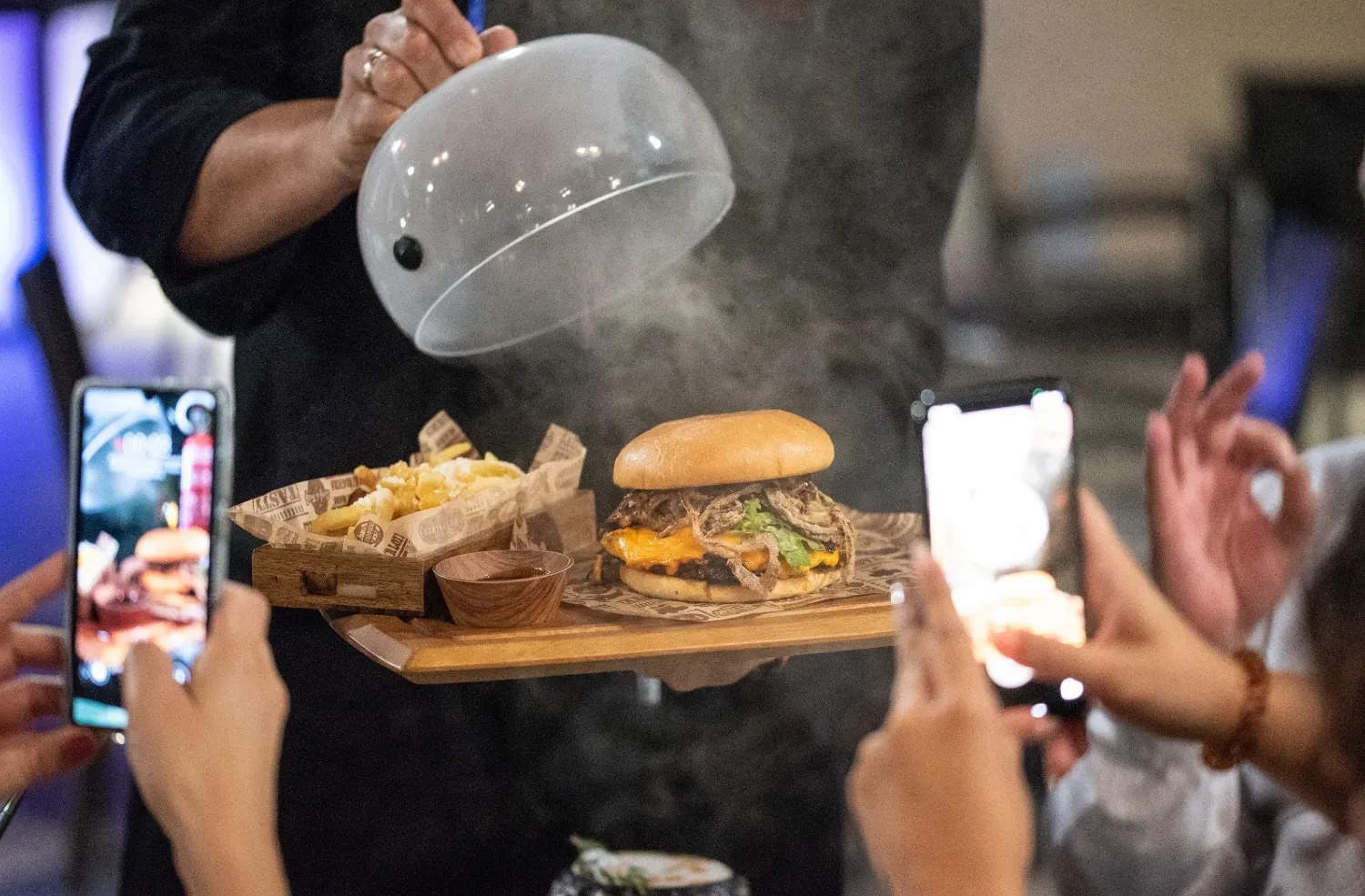 a person is taking a picture of a hamburger and french fries