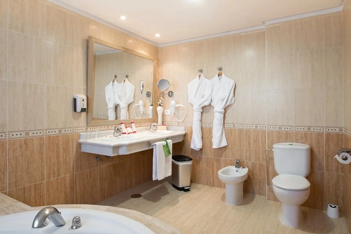 un baño de hotel con albornoz y bañera