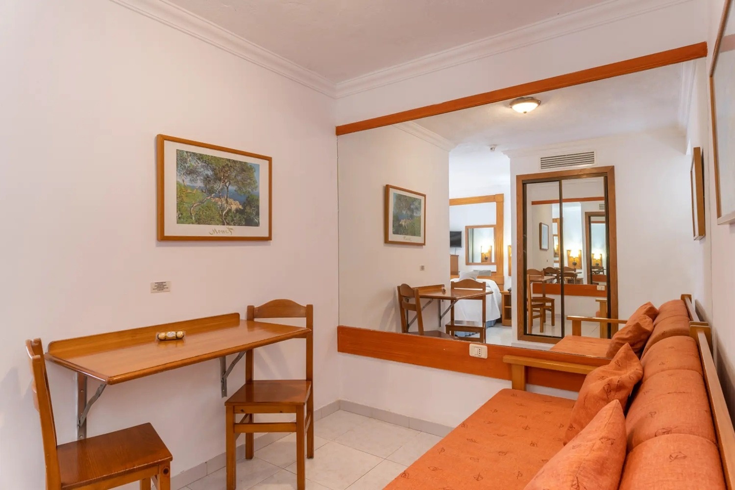 una habitación con un sofá y una mesa con una pintura en la pared