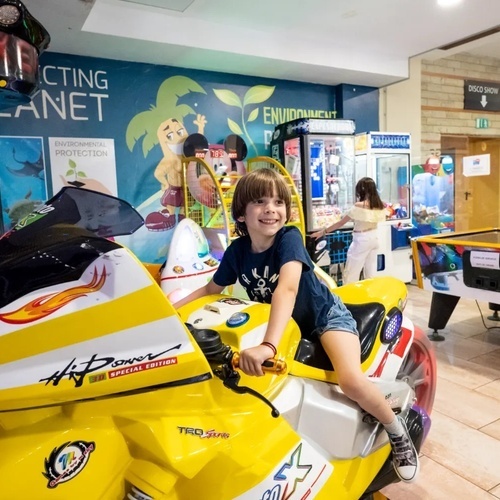 a boy sits on a yellow motorcycle that says hi power