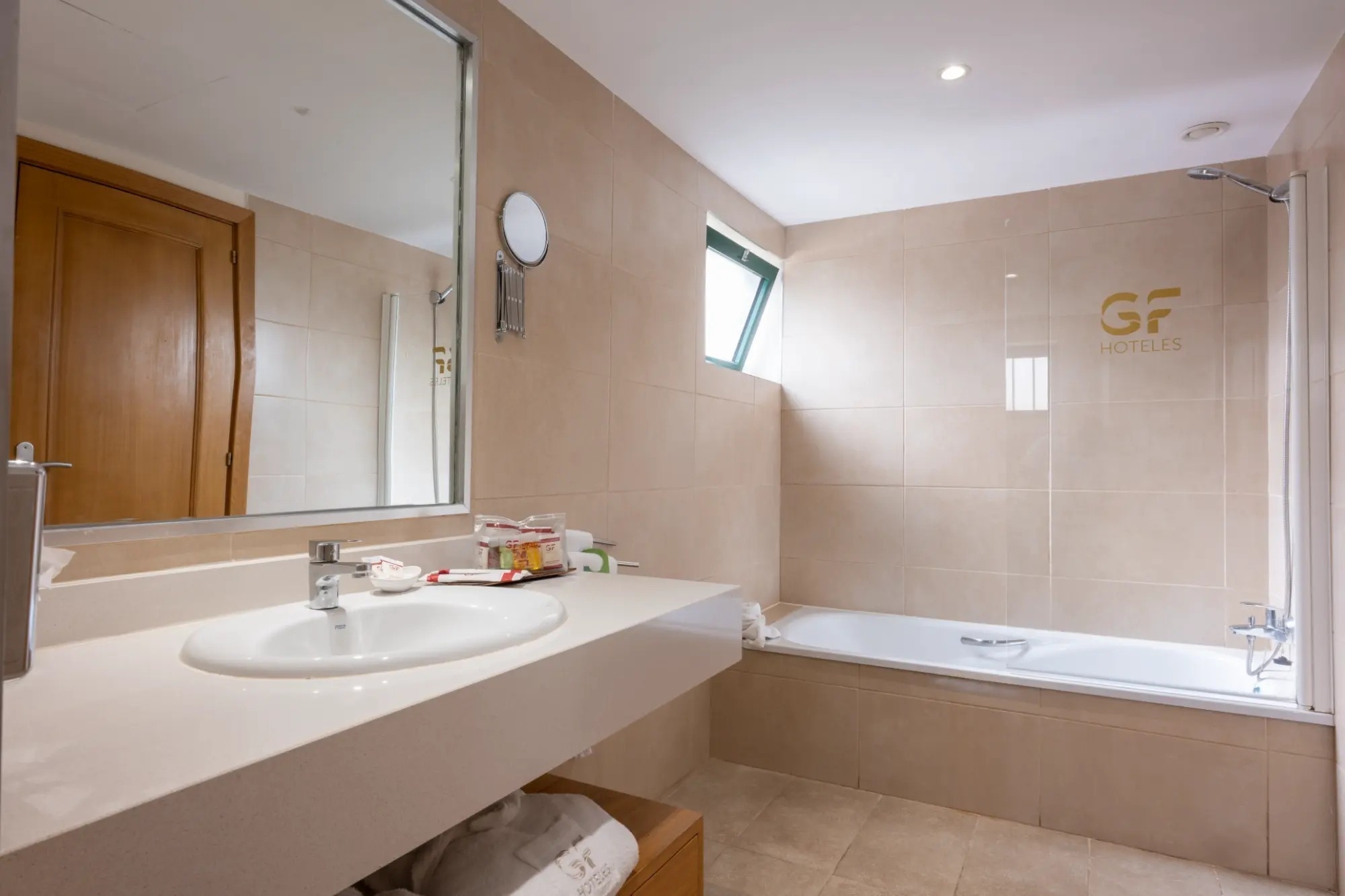 un baño con un lavabo y una bañera y la palabra hoteles en la pared