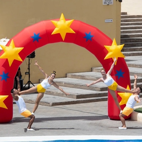a group of acrobats are performing in front of an inflatable arch with stars on it