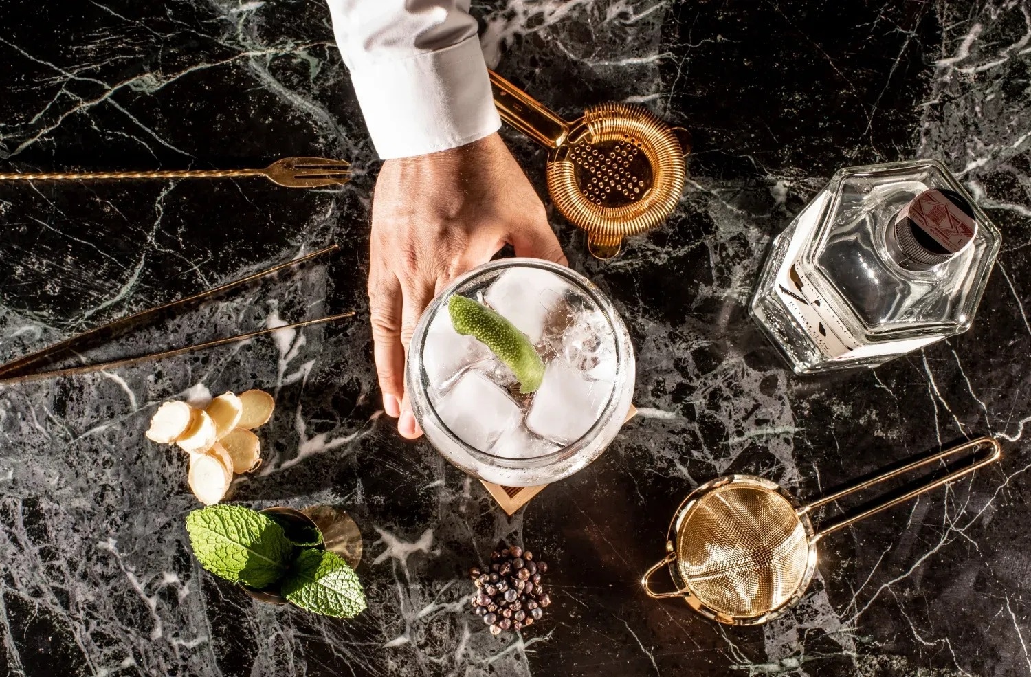 un barman prepara un cóctel en una mesa de mármol