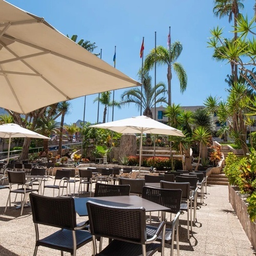 a patio area with tables and chairs and umbrellas with the letter e on the wall