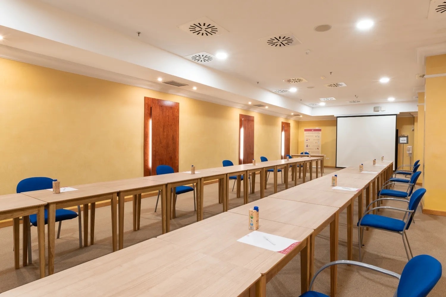 a conference room with a gf hoteles sign on the wall