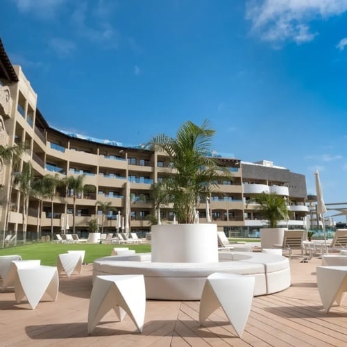 un gran edificio con sillas y mesas frente a él