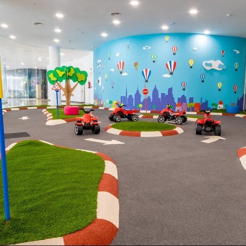 una pista de carreras para niños con un semáforo y un árbol