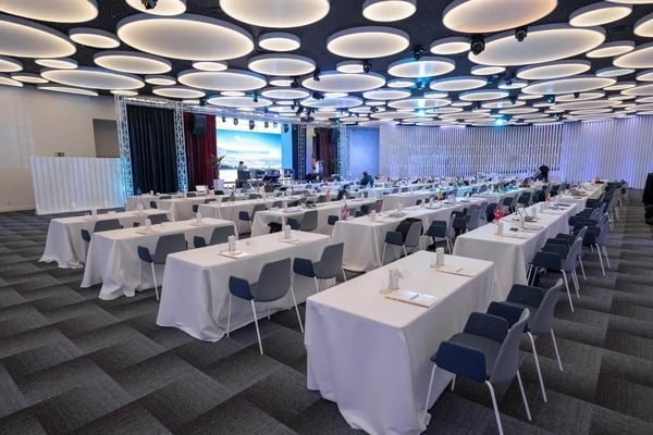 una sala de conferencias llena de mesas y sillas