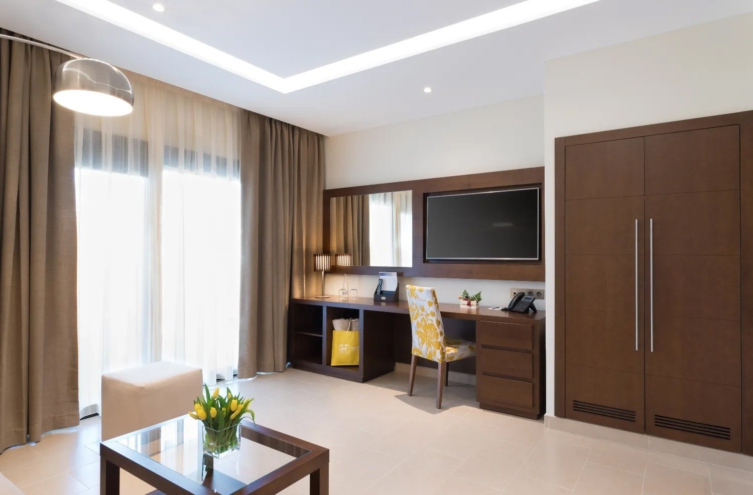 a hotel room with a desk and a flat screen tv