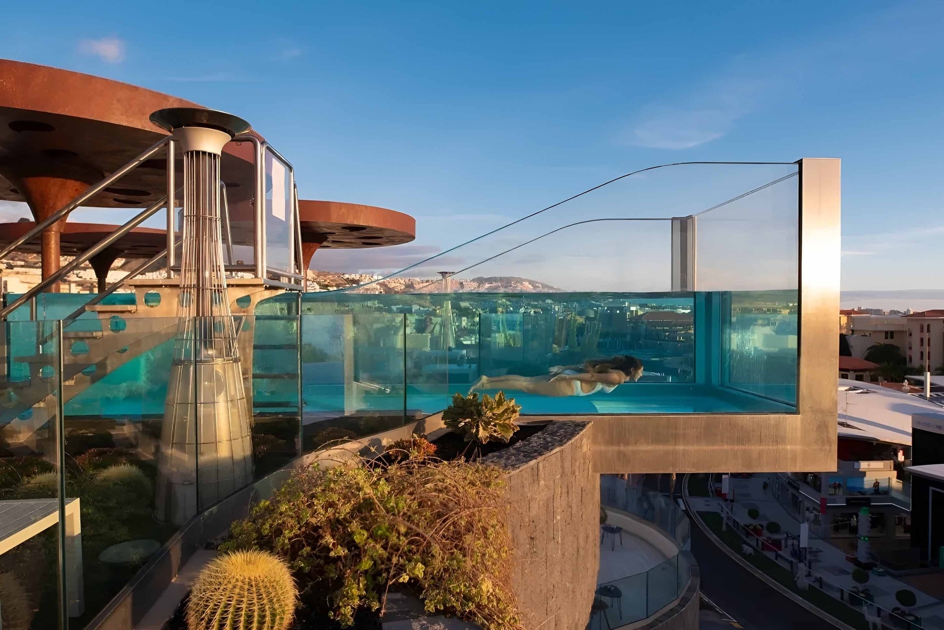 a woman is swimming in a pool on top of a building