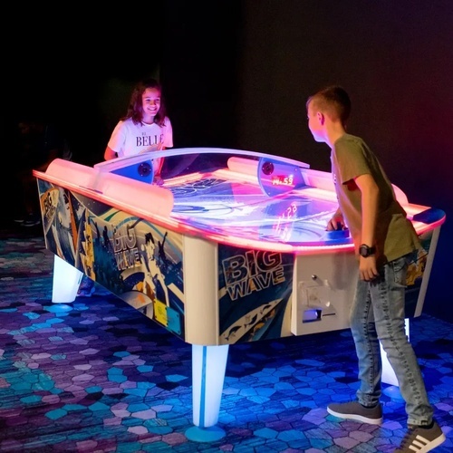 un niño y una niña juegan a un juego de mesa de hielo gigante