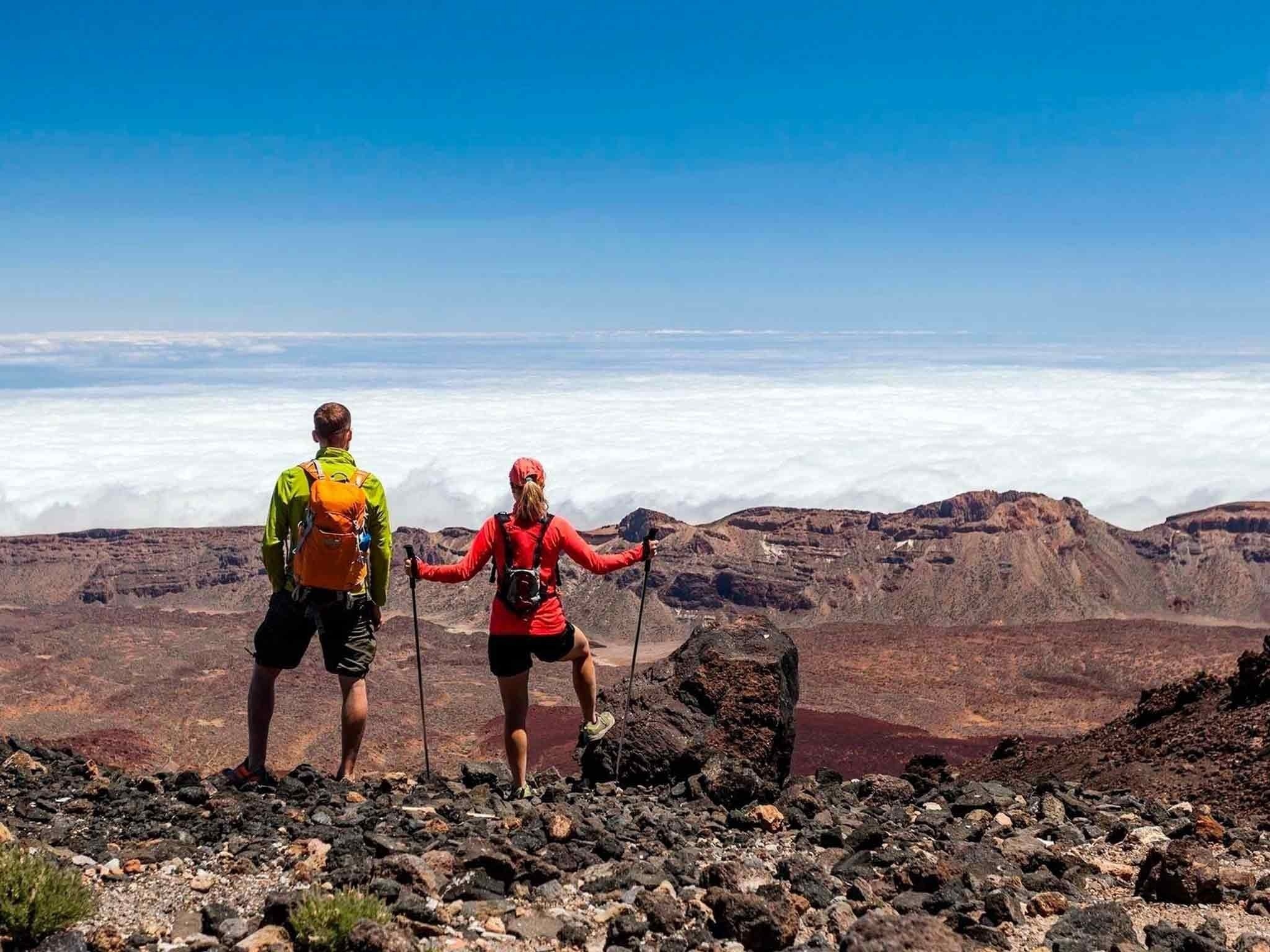 a man stands on a rocky beach near the ocean