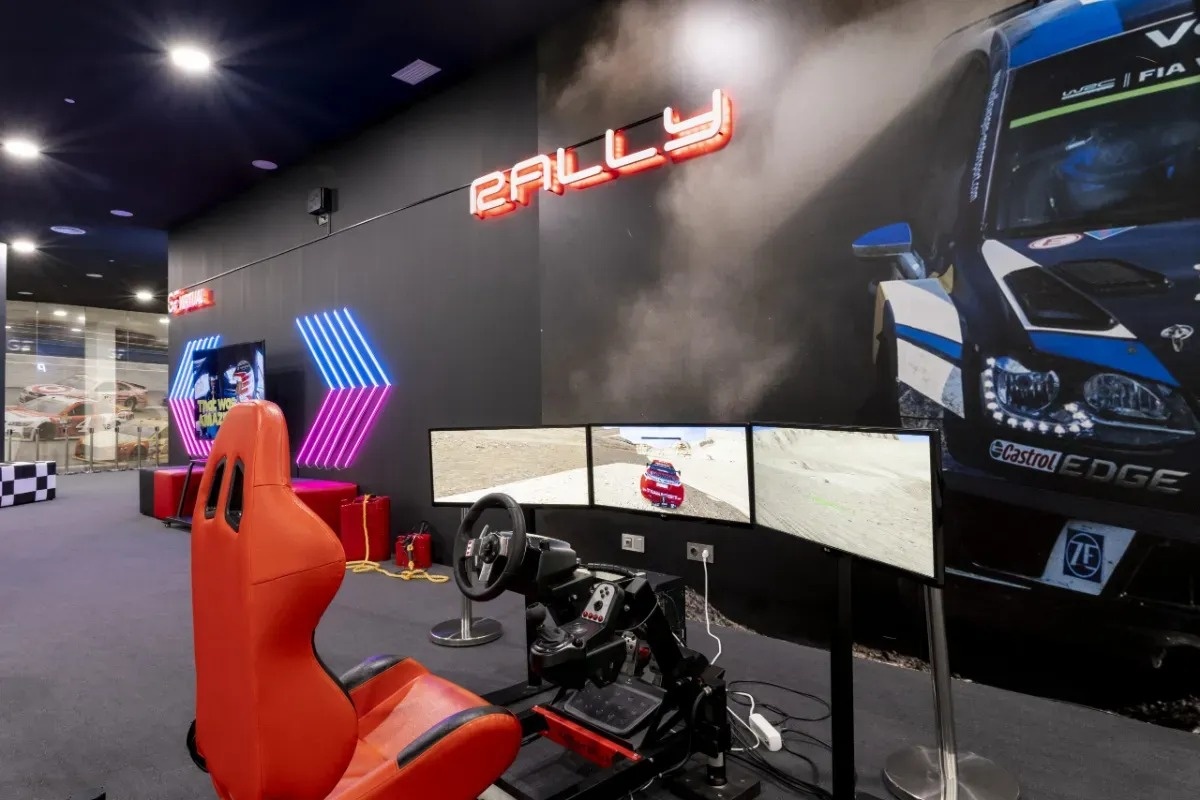 a red racing seat is in front of a wall that says rally