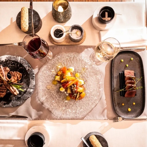 una mesa con platos de comida y copas de vino