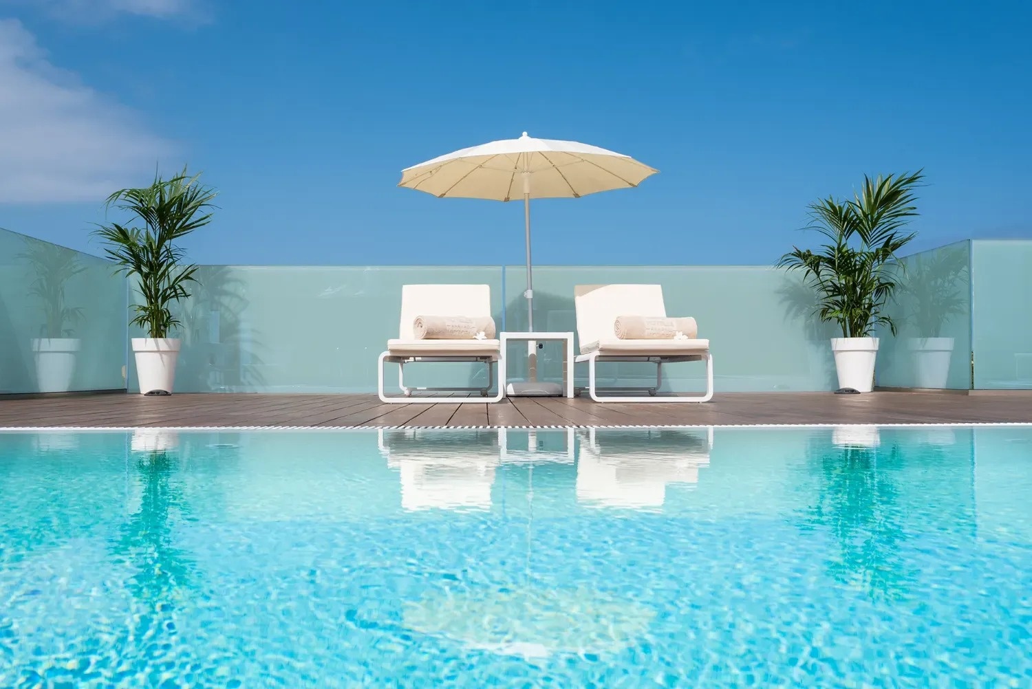a swimming pool with two chairs and an umbrella