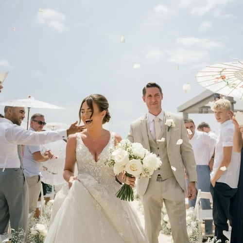 una novia y un novio caminan por el pasillo después de su ceremonia de boda