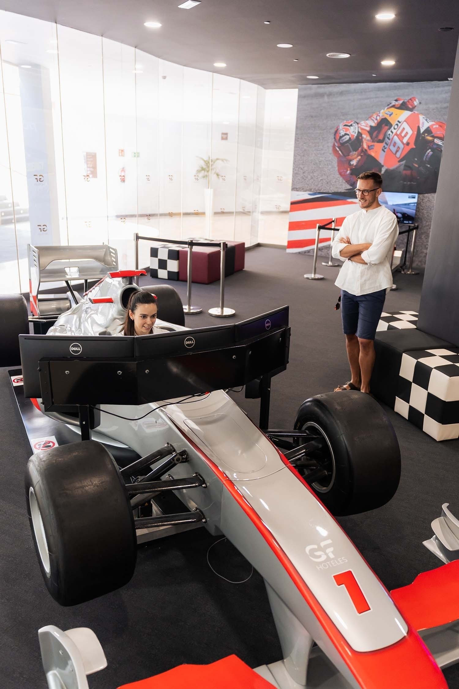 a woman sits in a race car with the number 1 on the side