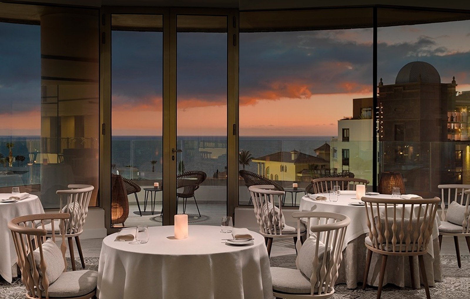 a restaurant with tables and chairs and a view of the ocean