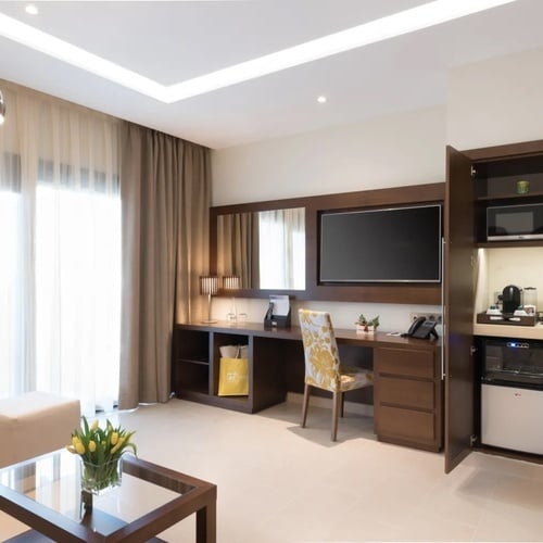 una habitación de hotel con un escritorio y una televisión