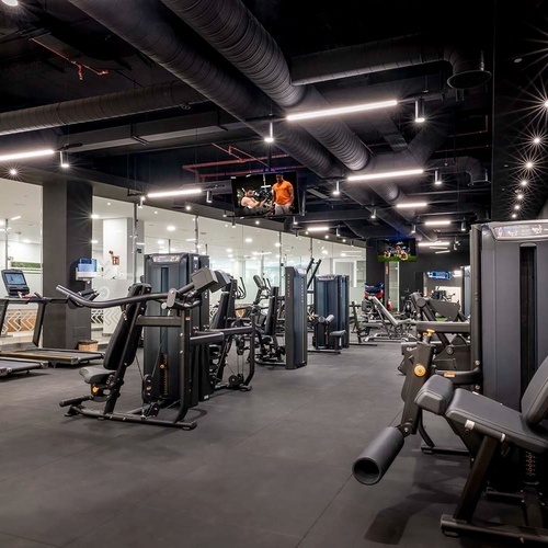 un gimnasio con muchos aparatos y una televisión
