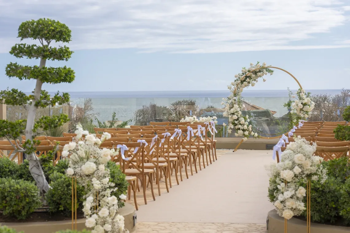 Boda exterior GF: Victoria con arco floral y asientos.