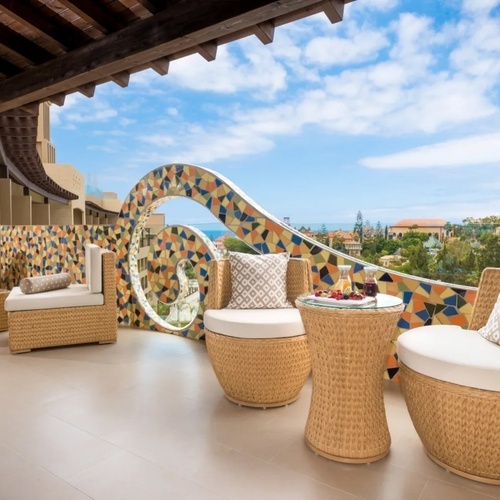 un balcón con muebles de mimbre y una mesa