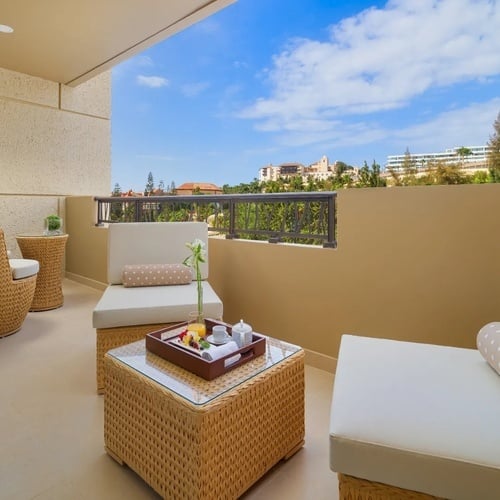 un balcón con muebles de mimbre y una bandeja de comida