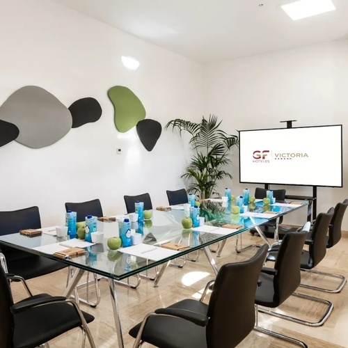 una habitación con una mesa y sillas y una pantalla que dice gf victoria