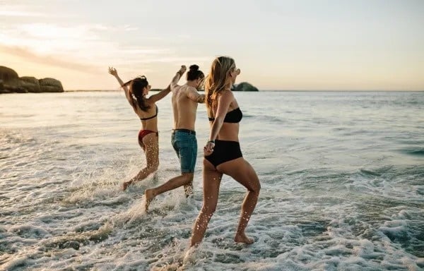 a person 's hand is reaching out into the ocean