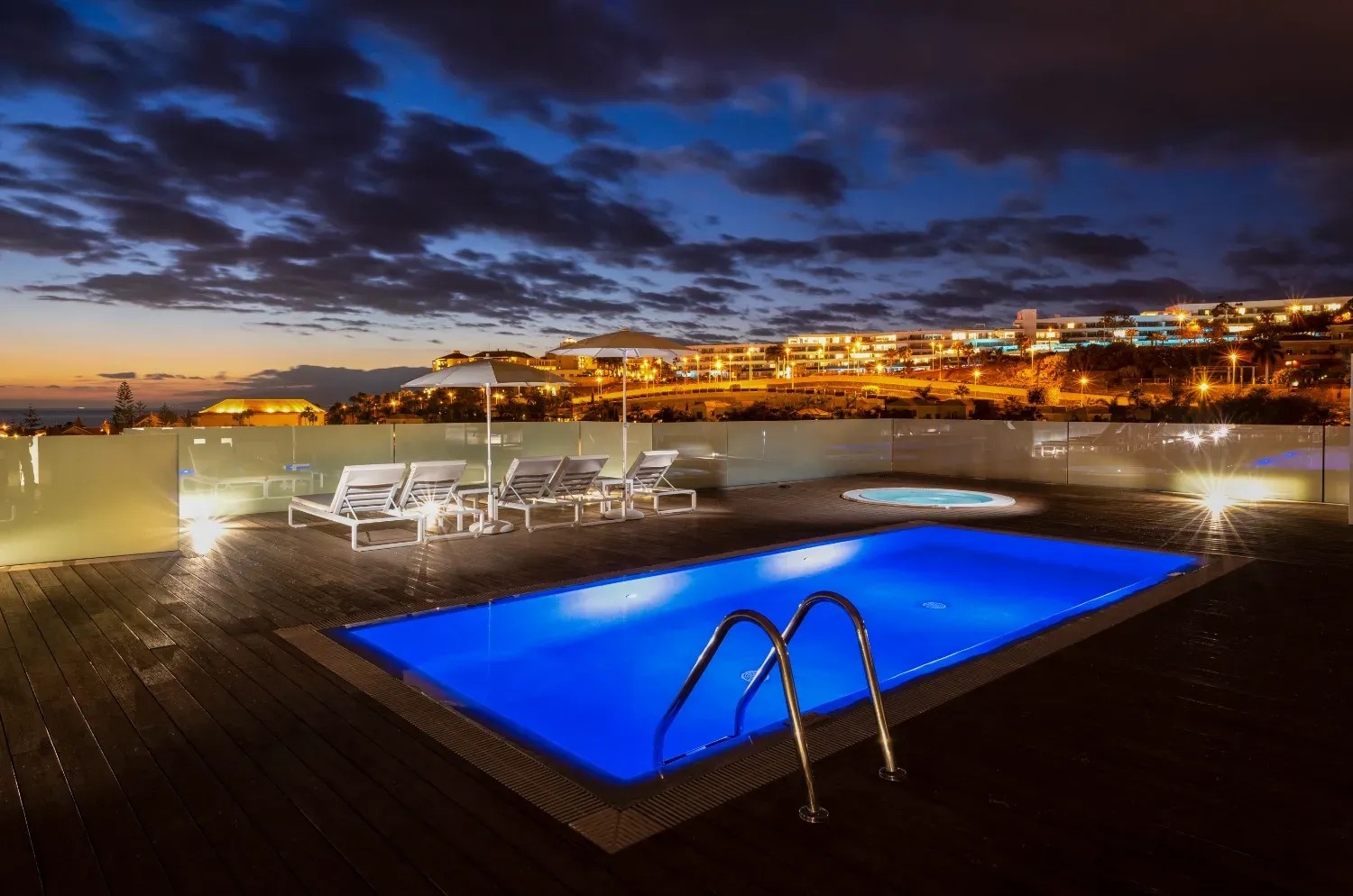 a large swimming pool is lit up at night