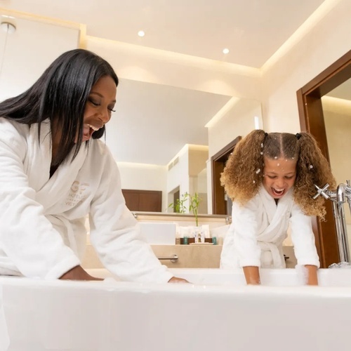 una mujer y una niña se sientan en una bañera en un baño