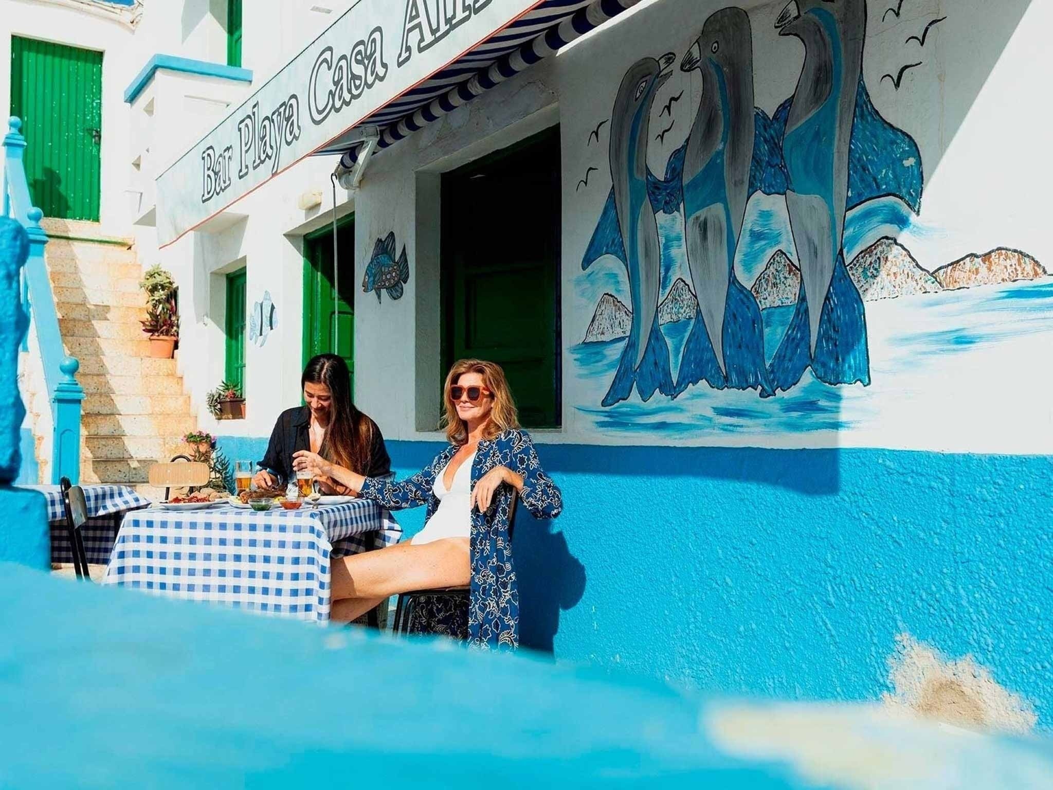 a man stands on a rocky beach near the ocean