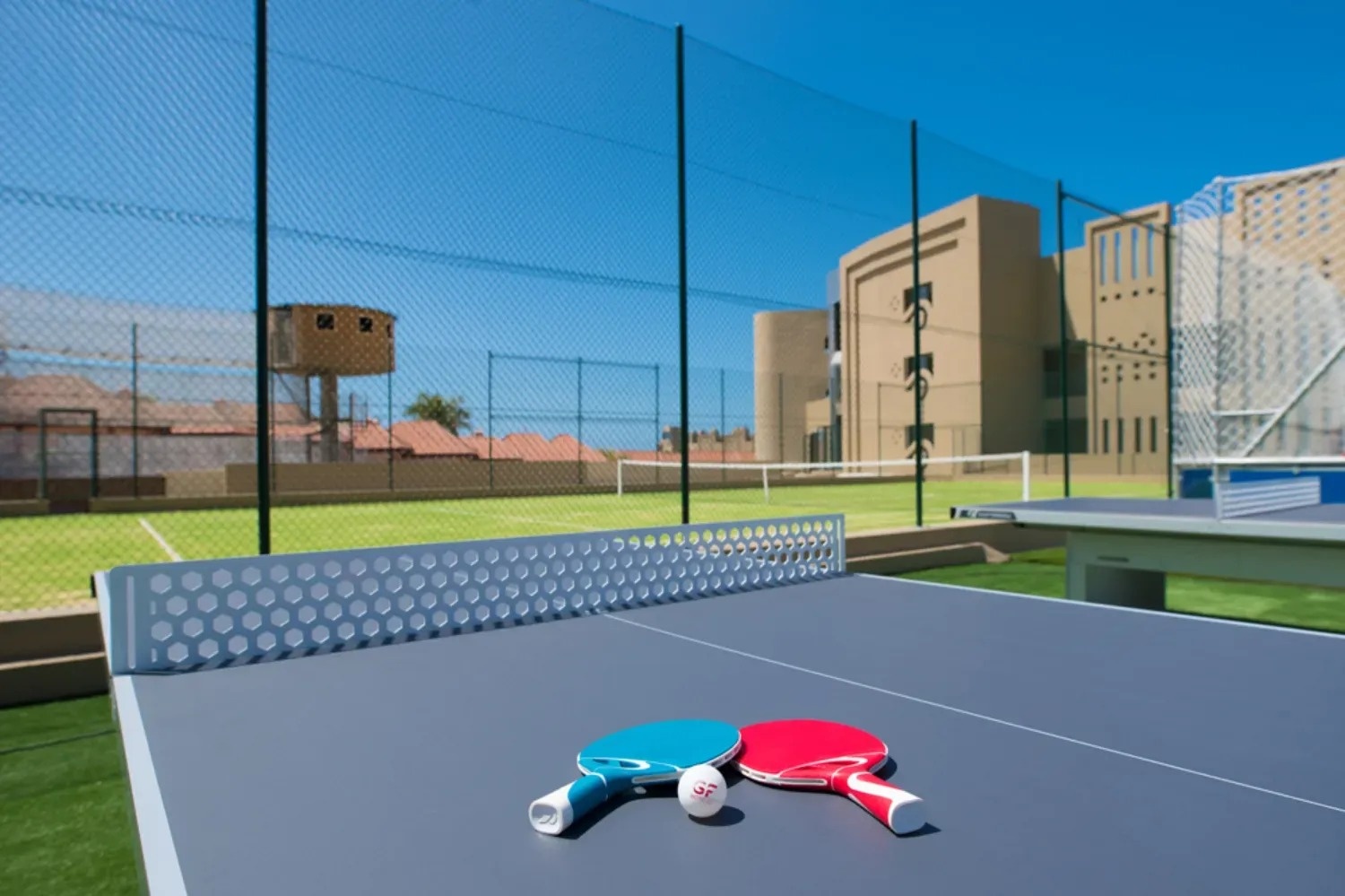 una mesa de ping pong con dos raquetas y una pelota