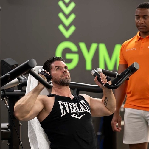 un hombre con una camiseta de everlast está haciendo ejercicio en un gimnasio