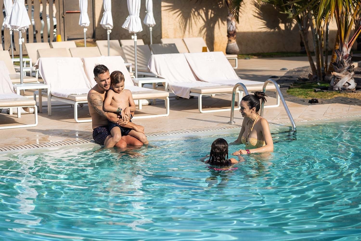 a family is playing in a swimming pool