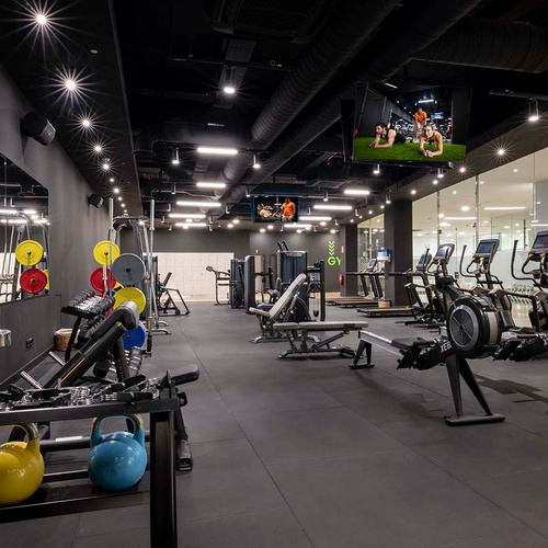 un gimnasio con muchos aparatos y una pantalla que dice nyr