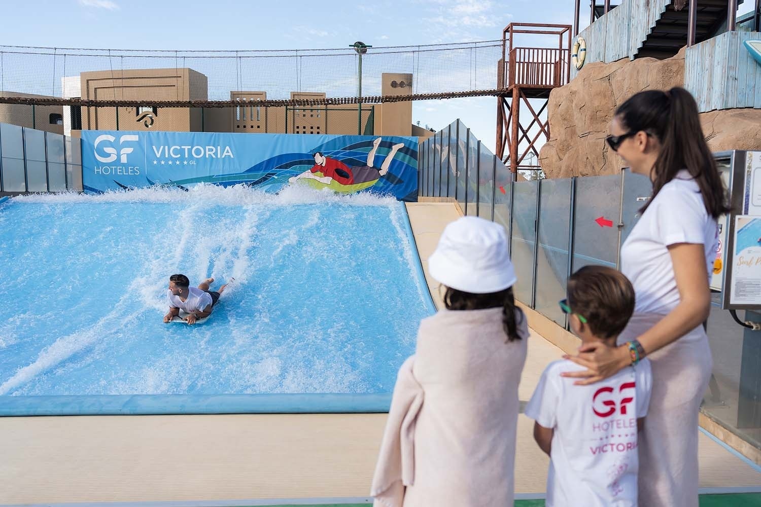a woman and two children are standing in front of a gf victoria sign