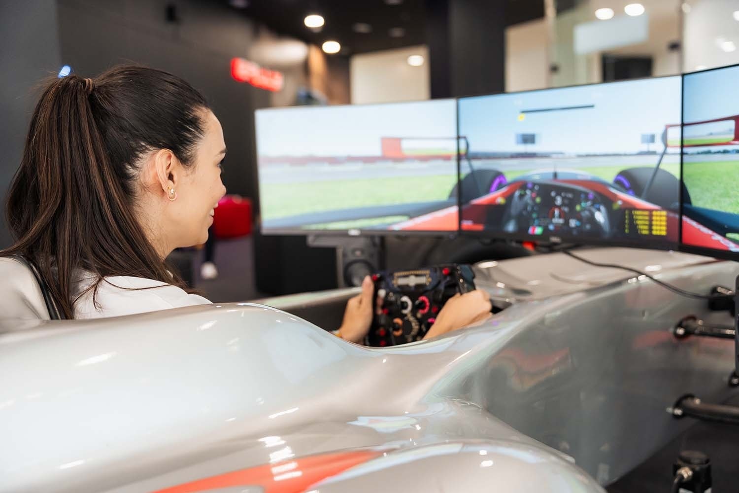 a woman is playing a video game in a race car