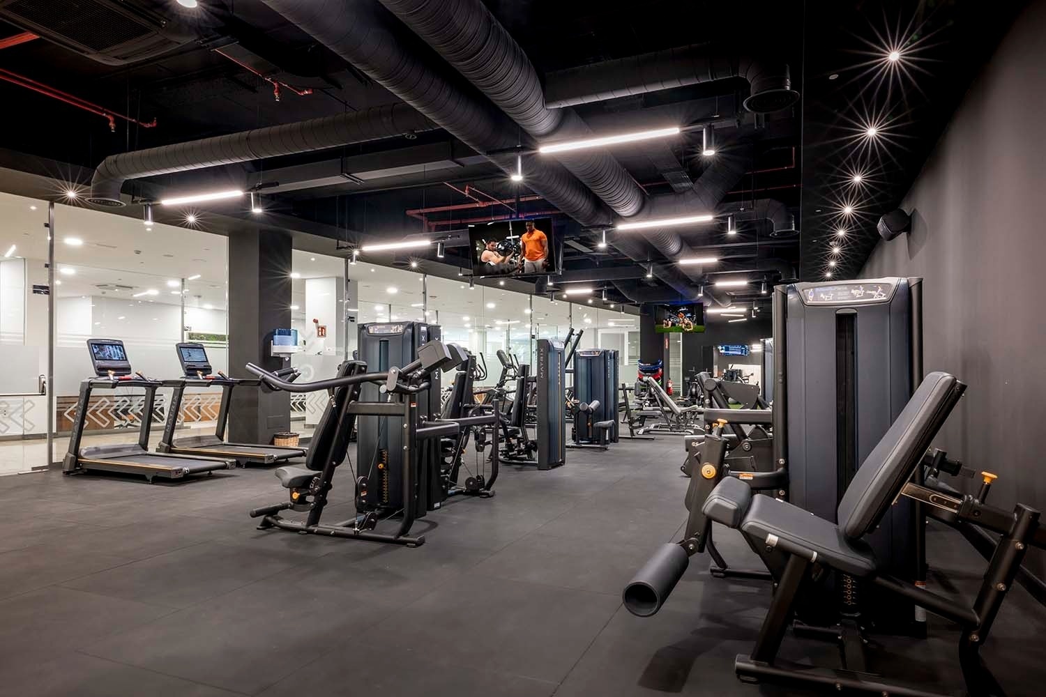 un gimnasio con muchos aparatos y una televisión