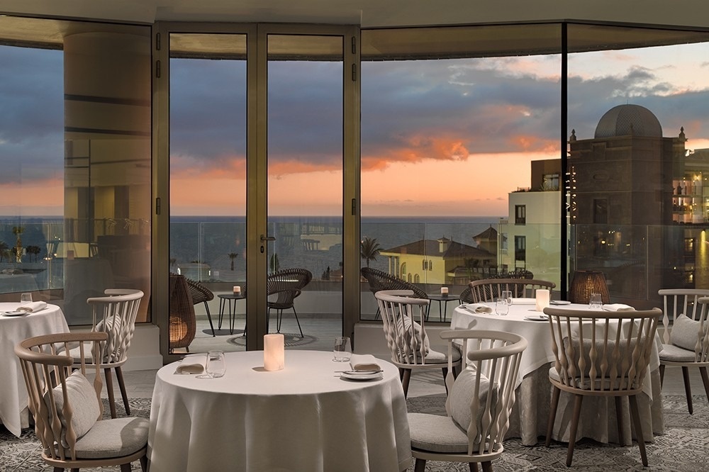 a beach at sunset with buildings in the background