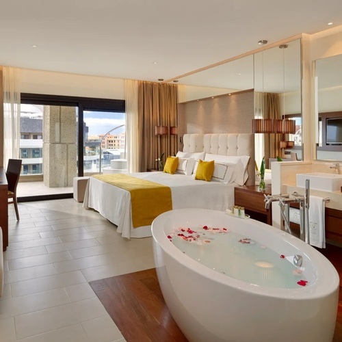 una habitación de hotel con una bañera y una cama