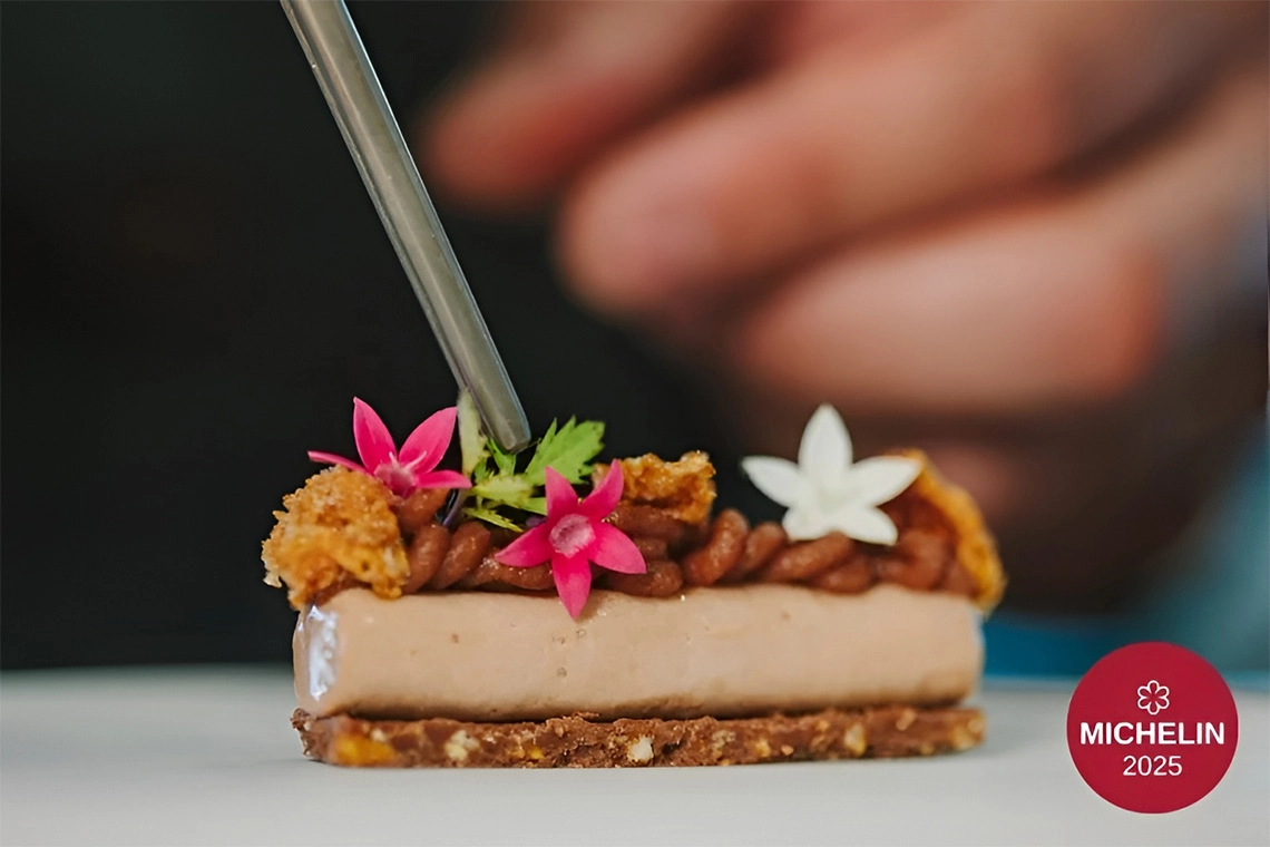 Postre gourmet con flores y logo de Michelin 2025 en hotel de lujo GF Victoria GL