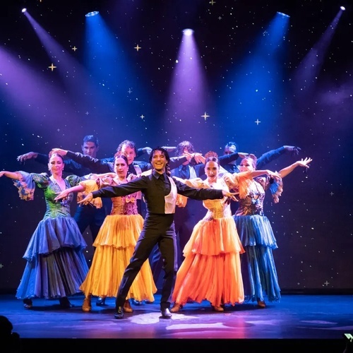un grupo de bailarines están actuando en un escenario con luces de colores