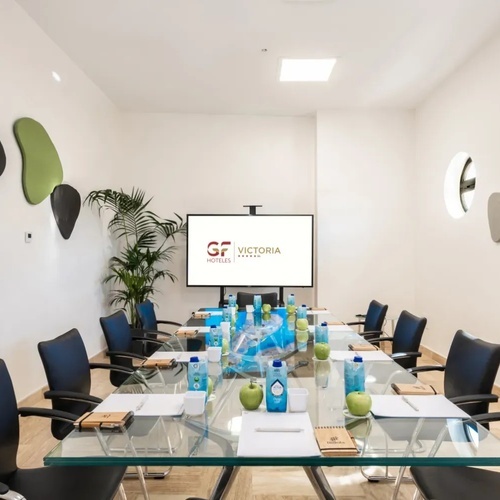 una sala de conferencias con una pantalla que dice gf victoria